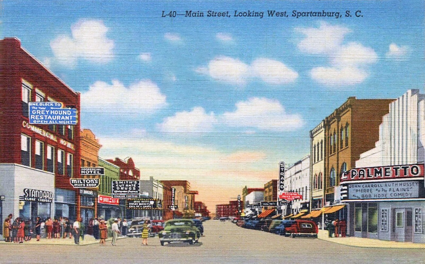 Main Street in Spartanburg on a 1940s postcard, lined with shop signs for the Palmetto theatre, Greyhound and local stores